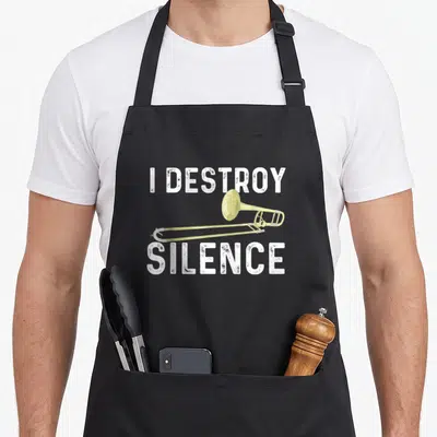 Destroy marching band apron - Gold trombone horizontally placed between white distressed text reading I DESTROY SILENCE — shown on a black cotton canvas apron against a white background