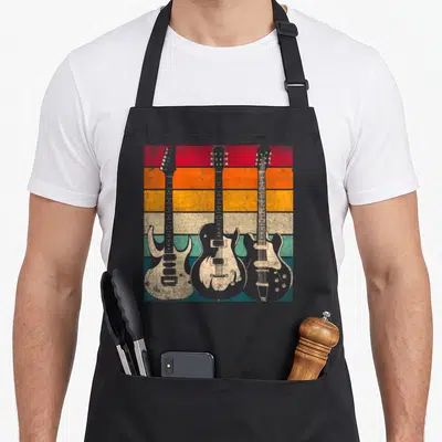 Guitar musical apron - Three electric guitars on horizontal red orange yellow green teal grey stripes — shown on a black cotton canvas apron against a white background