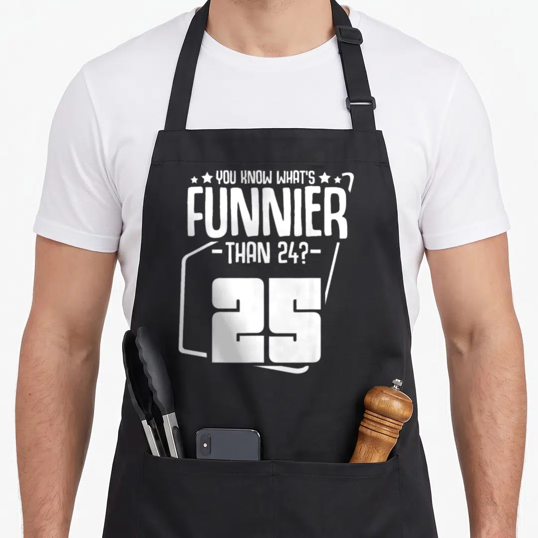 Funnier birthday apron - White stacked text reading YOU KNOW WHAT'S FUNNIER THAN 24? 25 with a border around the number — shown on a black cotton canvas apron against a white background