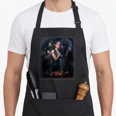 Cute resident apron - Woman flanked by two men and monster with clock tower and zombies below text — shown on a black cotton canvas apron against a white background