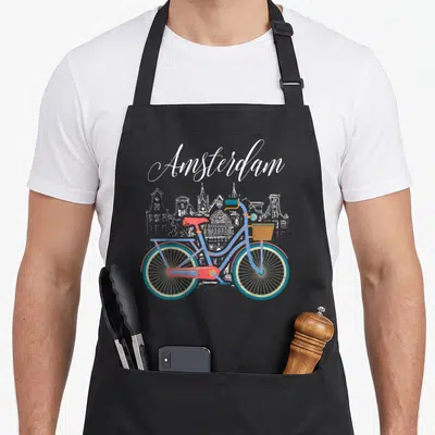 Luv bike apron - Colorful bicycle in front of white Amsterdam skyline sketch — shown on a black cotton canvas apron against a white background