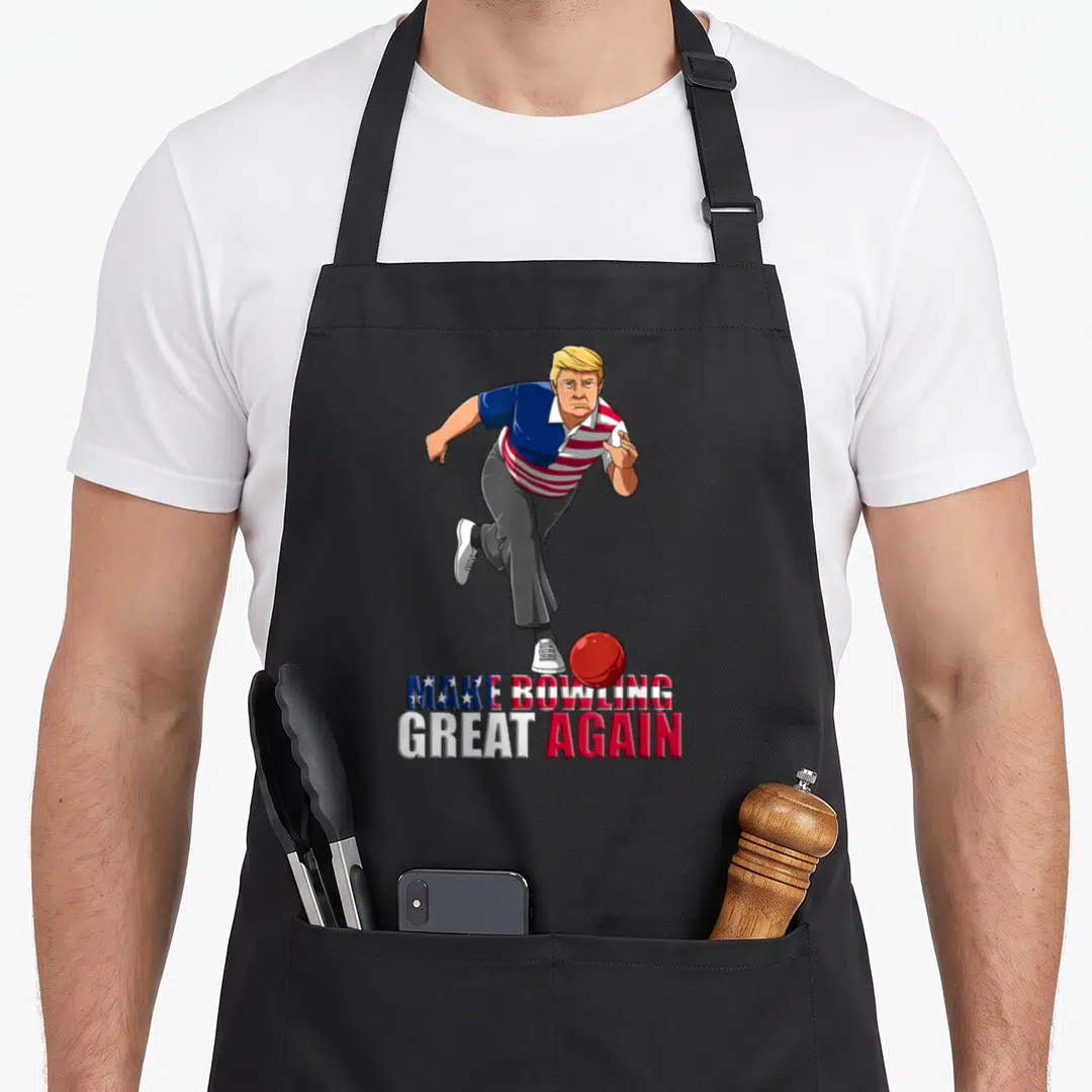 Trump bowling apron - Cartoon man bowling with red ball and stacked patriotic text below — shown on a black cotton canvas apron against a white background