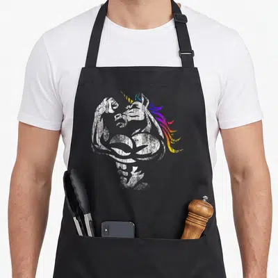 Muscle father day apron - Distressed white muscular unicorn flexing arm with rainbow gradient mane in blue purple pink — shown on a black cotton canvas apron against a white background