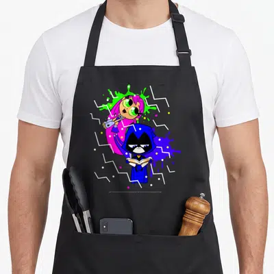 Starfire ravens aprons - Cartoon raven holding book with Starfire behind amidst blue pink green purple splashes — shown on a black cotton canvas apron against a white background