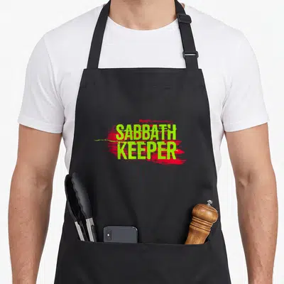Sabbath hebrew aprons - SABBATH KEEPER text in lime green over red paint splash graphic — shown on a black cotton canvas apron against a white background