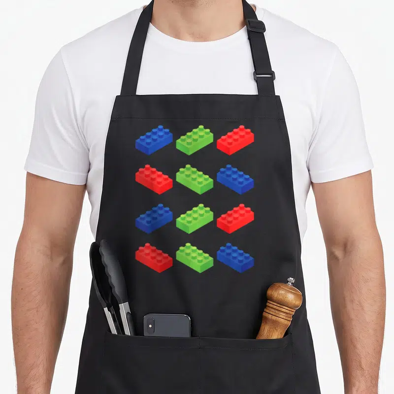 Brick master block & apron - Twelve blue green and red building blocks in a four by three grid pattern — shown on a black cotton canvas apron against a white background