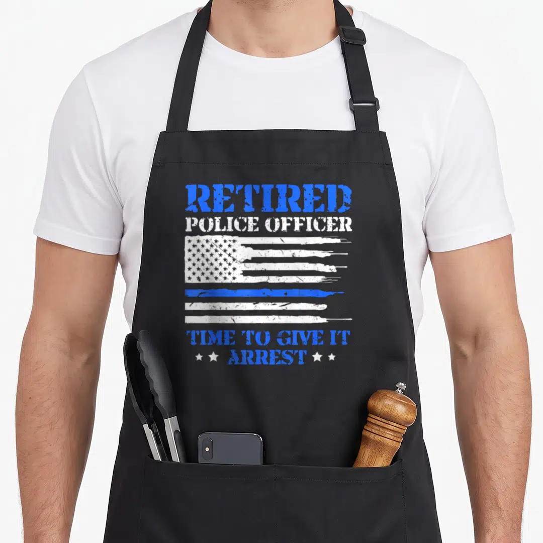 Police modern apron - Distressed flag with blue stripe and text retired police officer time to give it arrest — shown on a black cotton canvas apron against a white background