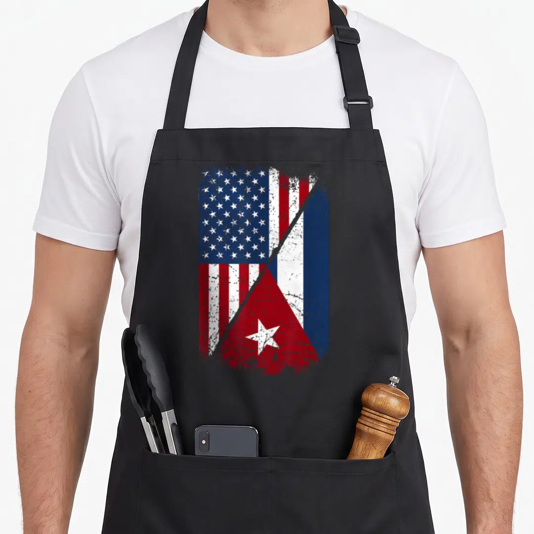 Cuba american flag apron - Distressed merge of US and Cuban flags in red white and blue split diagonally — shown on a black cotton canvas apron against a white background