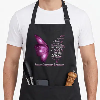 Storm caregiver apron - Purple butterfly with I Am The Storm text and awareness ribbons — shown on a black cotton canvas apron against a white background