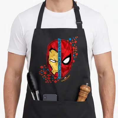 Homecoming split apron - Split Iron Man and Spider-Man mask with blue divider bar and scattered red blue squares — shown on a black cotton canvas apron against a white background