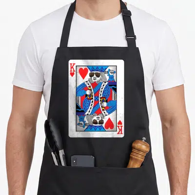 Night king apron - Mirrored king of hearts playing card with sunglasses and beer bottles in white blue red — shown on a black cotton canvas apron against a white background