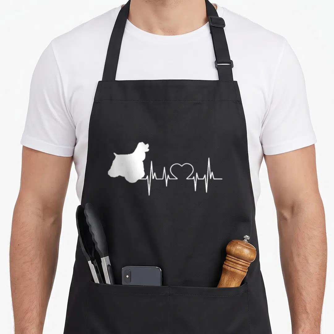 Heartbeat cocker spaniel apron - White dog silhouette connected to heartbeat line with heart shape in center — shown on a black cotton canvas apron against a white background