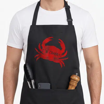 Sea crab apron - Red distressed crab with I'M CRABBY! text overlay — shown on a black cotton canvas apron against a white background