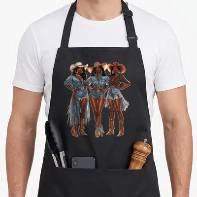 Texas western aprons - Three cowgirls facing forward in denim and cowboy hats printed in blue, brown, white, and tan — shown on a black cotton canvas apron against a white background