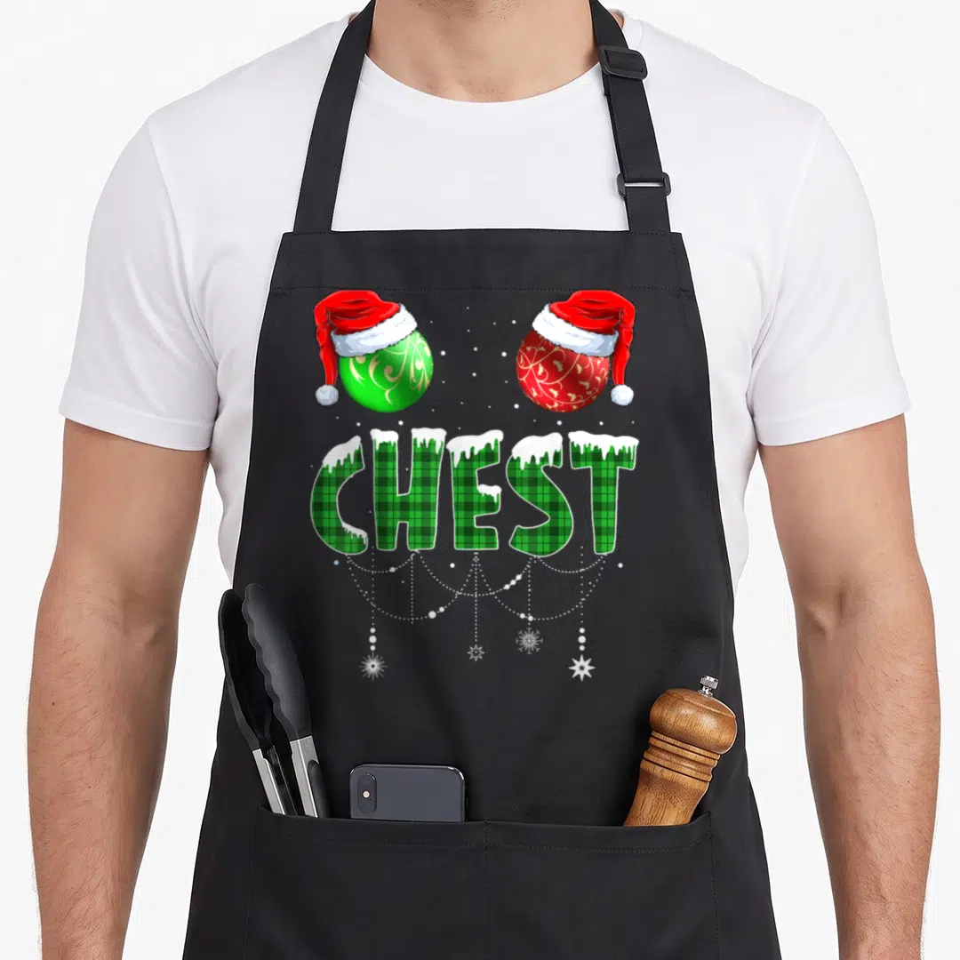 Chest family christmas aprons - Green plaid CHEST text with snow, two Santa hat ornaments, and white string lights — shown on a black cotton canvas apron against a white background