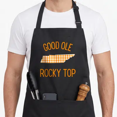 Tennessee buffalo apron - Orange and white plaid Tennessee state map with Good Ole Rocky Top text — shown on a black cotton canvas apron against a white background