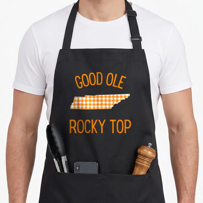 Tennessee buffalo apron - Orange and white plaid Tennessee state map with Good Ole Rocky Top text — shown on a black cotton canvas apron against a white background