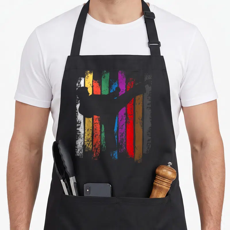 Belt karate apron - Grey silhouette of person in front of vertical white yellow orange green blue purple red brown — shown on a black cotton canvas apron against a white background
