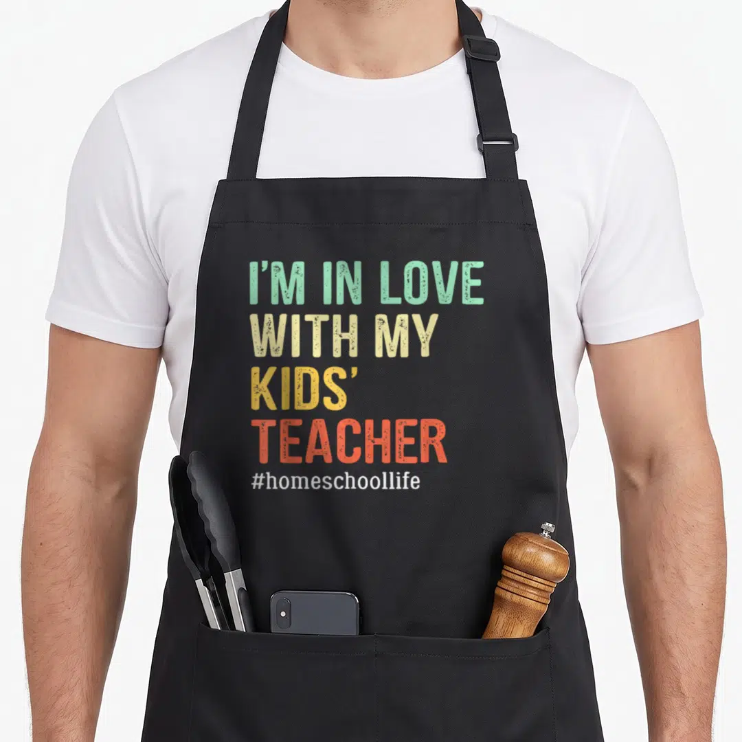 Mama cute teacher apron - Stacked I'M IN LOVE WITH MY KIDS' TEACHER text in mint beige yellow orange white — shown on a black cotton canvas apron against a white background