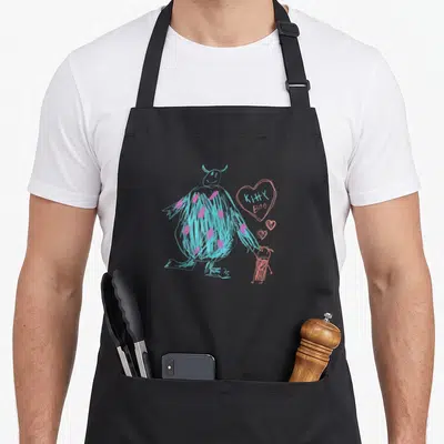 Sulley kitty aprons - Blue monster holding pink child hand with heart reading KITTY BOO in line art — shown on a black cotton canvas apron against a white background