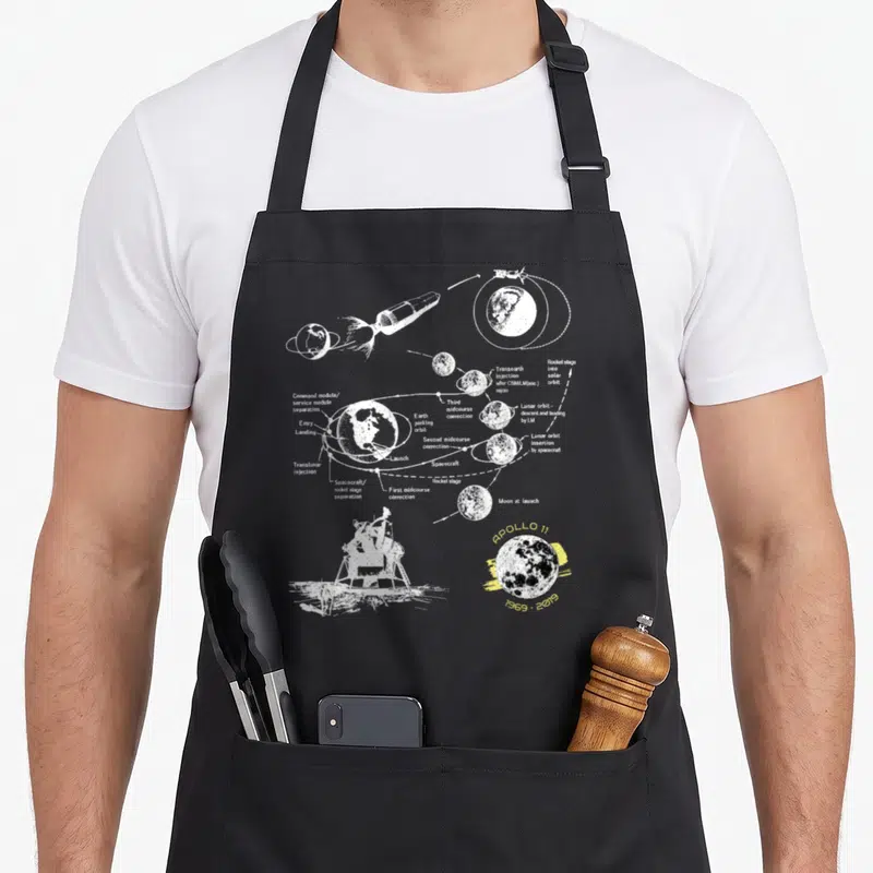 Mission apollo apron - White line-art Apollo 11 mission diagram on black apron — shown on a black cotton canvas apron against a white background