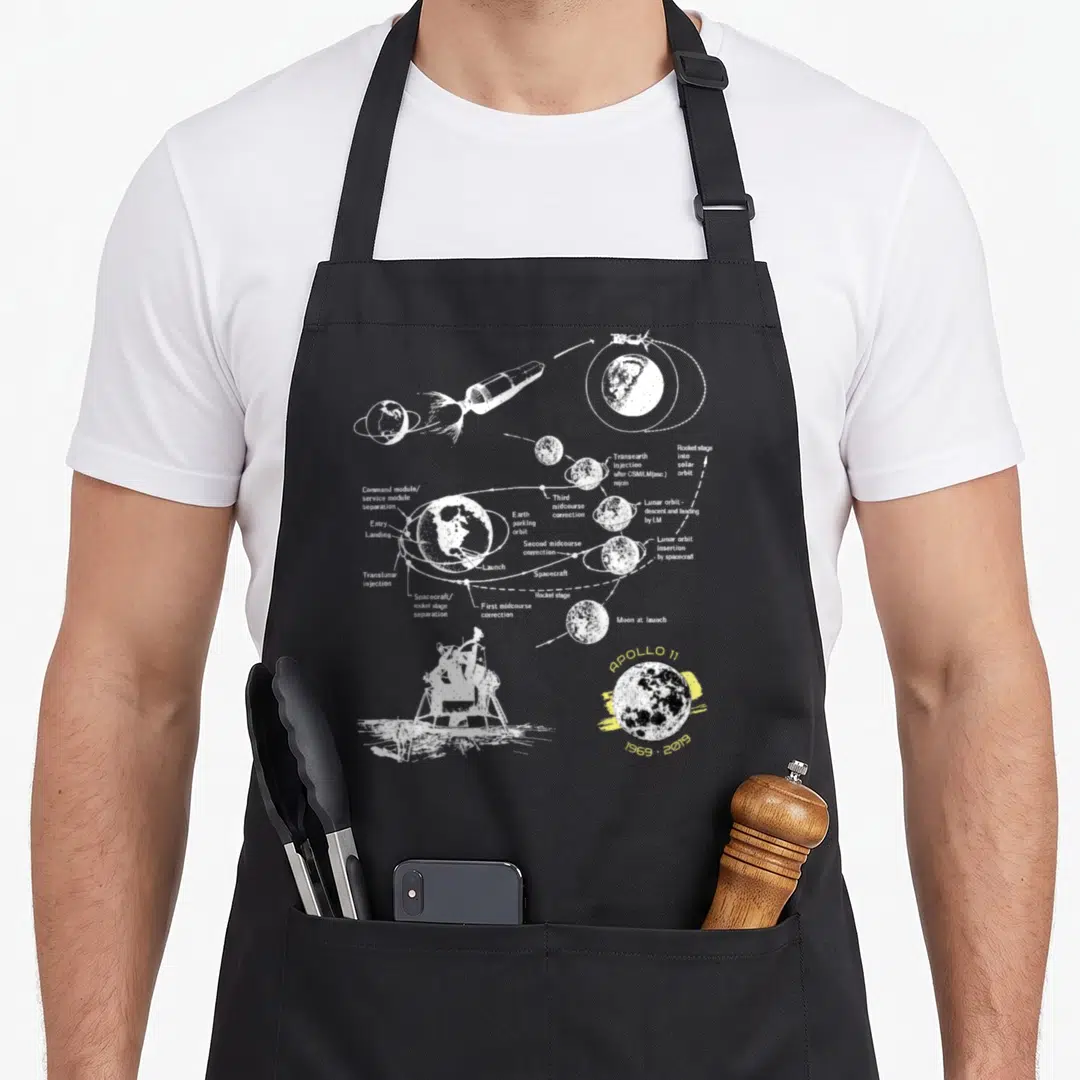 Mission apollo apron - White line-art Apollo 11 mission diagram on black apron — shown on a black cotton canvas apron against a white background