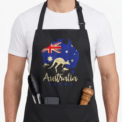 Wildlife kangaroo apron - Distressed Australia map with flag, three kangaroos, and stars over black bib — shown on a black cotton canvas apron against a white background