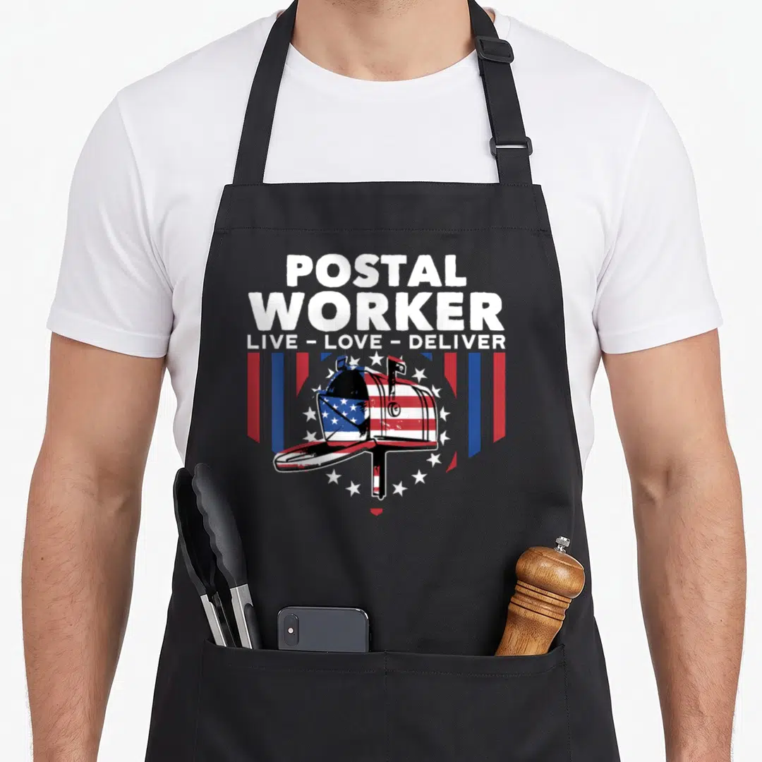 Deliver postal aprons - Stacked postal worker text above a flag-patterned mailbox flanked by red white blue stripes — shown on a black cotton canvas apron against a white background