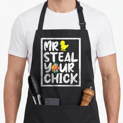 Toddler spring apron - Yellow chick and floral egg above stacked white text Mr Steal Your Chick in distressed font — shown on a black cotton canvas apron against a white background