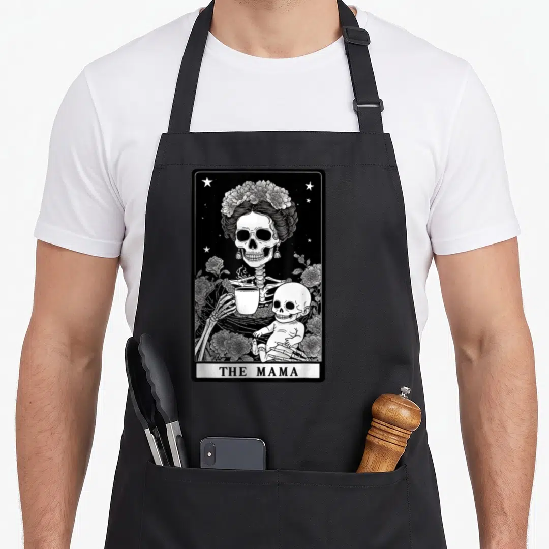 Gothic mother's day aprons - Skeleton mother with flower crown holding coffee and baby skeleton in tarot card style — shown on a black cotton canvas apron against a white background