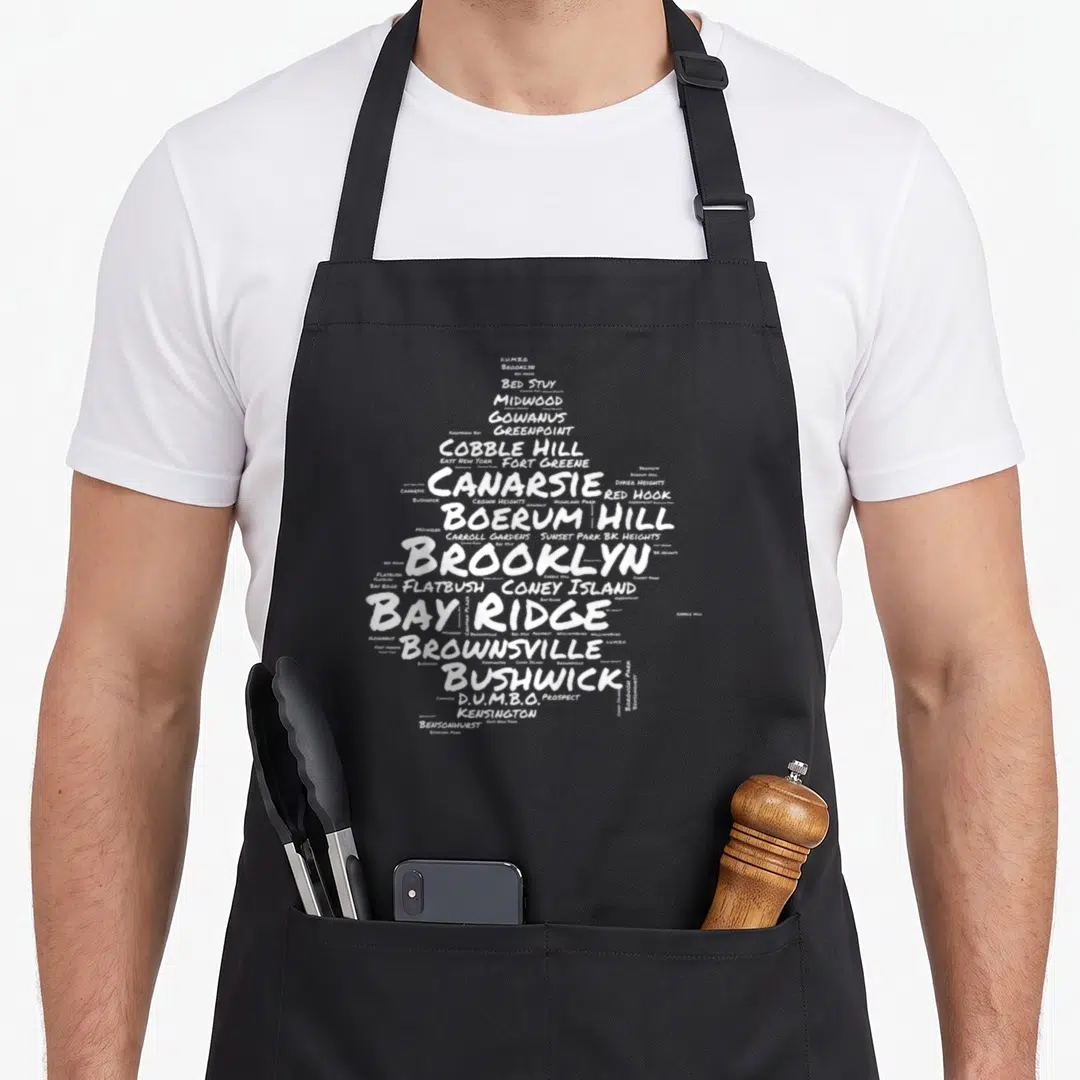 Neighborhood brooklyn apron - White word cloud of DUMBO, Greenpoint, Coney Island, and Brooklyn neighborhoods — shown on a black cotton canvas apron against a white background