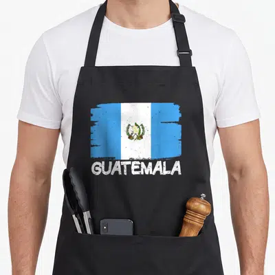 Funny flag guatemala apron - Distressed blue white and green flag print above bold white guatemala text — shown on a black cotton canvas apron against a white background