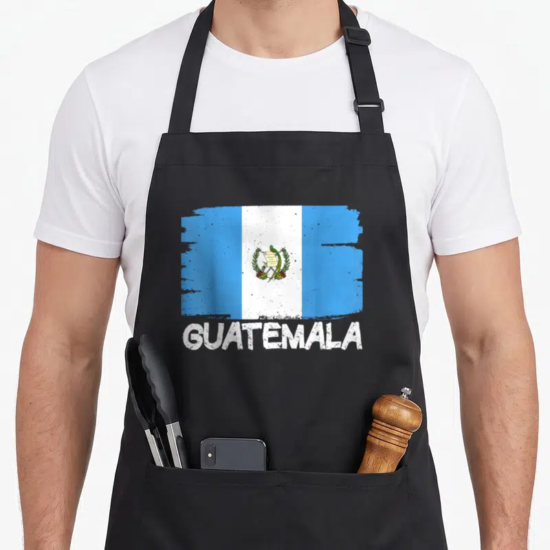 Funny flag guatemala apron - Distressed blue white and green flag print above bold white guatemala text — shown on a black cotton canvas apron against a white background