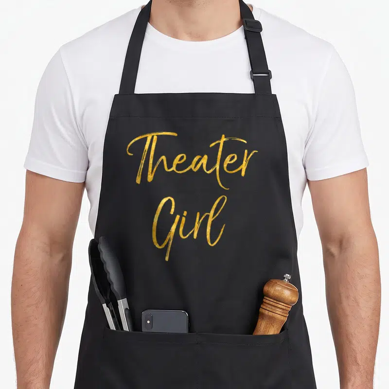Broadway theatre apron - Gold script text reading Theater Girl stacked vertically — shown on a black cotton canvas apron against a white background