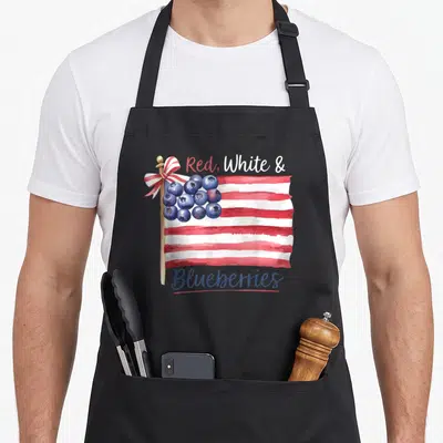 Supporter blueberries apron - Watercolor flag with red white stripes and blueberry canton with text — shown on a black cotton canvas apron against a white background