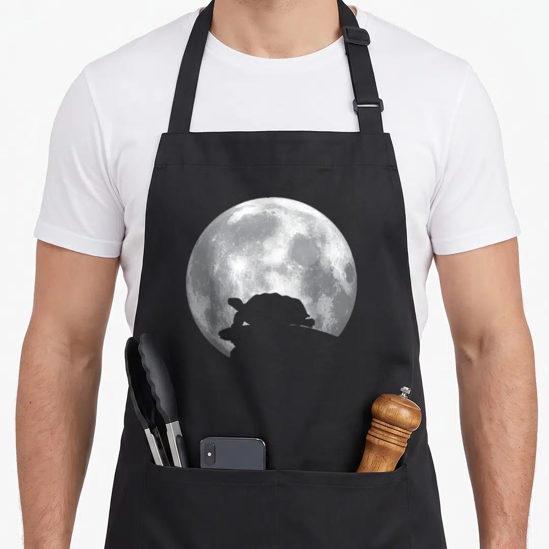Turtle russian apron - White and grey full moon with a dark turtle silhouette overlapping the bottom edge — shown on a black cotton canvas apron against a white background