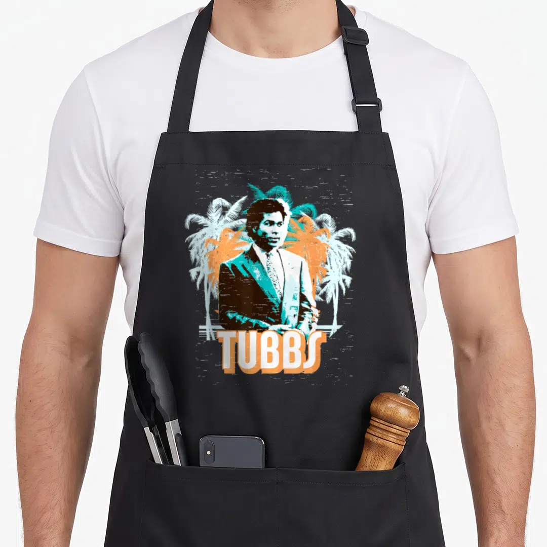 Tubb tree apron - Retro man in suit with orange and blue palm trees and TUBBS text — shown on a black cotton canvas apron against a white background