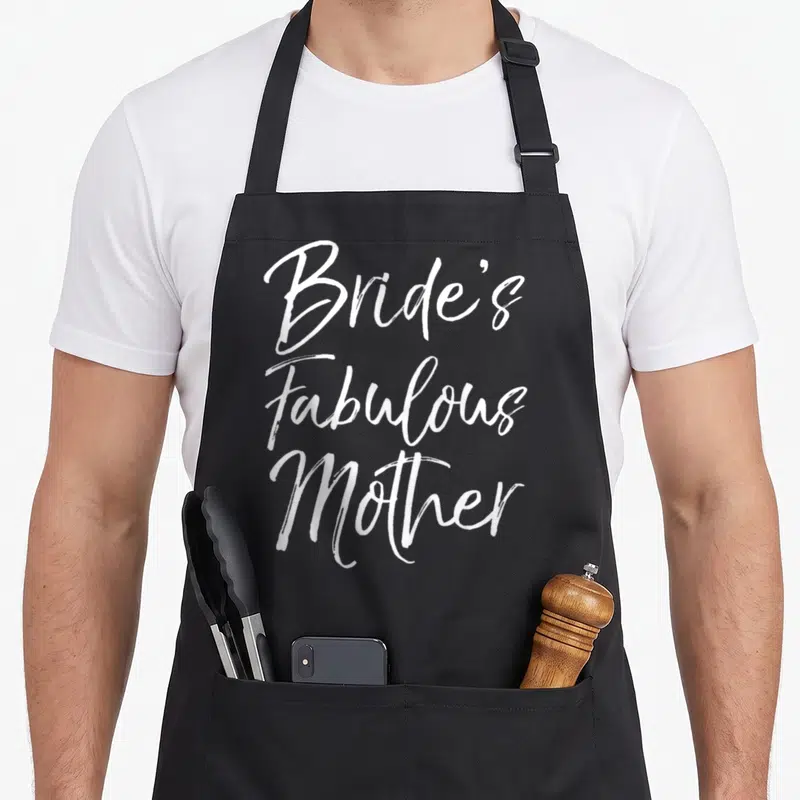 Bride fabulous bridal apron - White script text reading Bride's Fabulous Mother stacked vertically — shown on a black cotton canvas apron against a white background