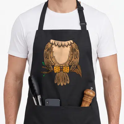 Headless easy apron - Cartoon brown eagle perched on branch with yellow claws and two small green leaves — shown on a black cotton canvas apron against a white background