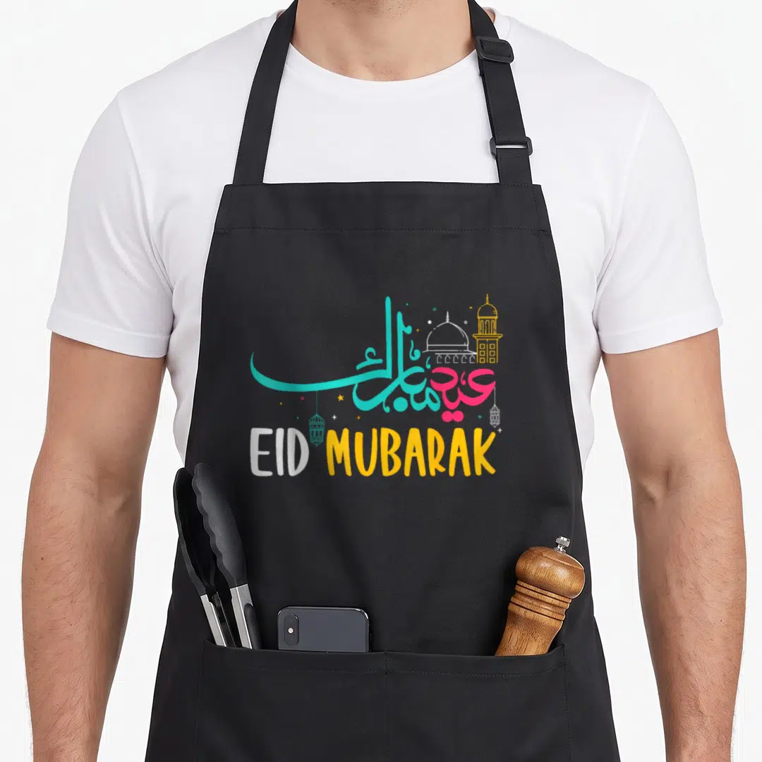 Ramadan eid al fitr apron - EID MUBARAK calligraphy with teal pink yellow mosque lanterns and stars — shown on a black cotton canvas apron against a white background