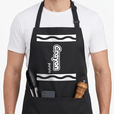 Crayon easy apron - Vertical white Crayon purple text with two wavy horizontal bands — shown on a black cotton canvas apron against a white background