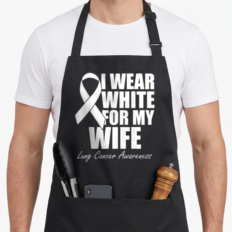 Lung wife apron - White ribbon next to I WEAR WHITE FOR MY WIFE text — shown on a black cotton canvas apron against a white background