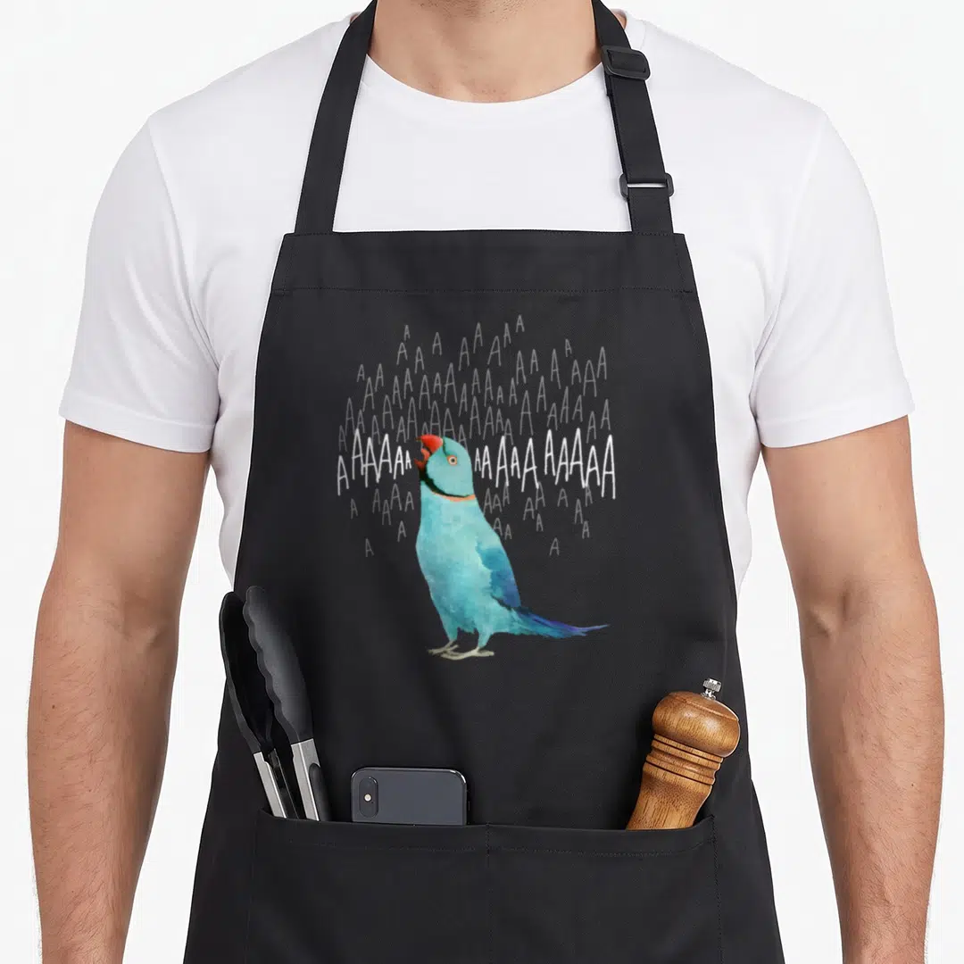 Screaming ringneck parakeet apron - Blue watercolor parrot with red beak and white screaming text AAAAAAAAAAA — shown on a black cotton canvas apron against a white background