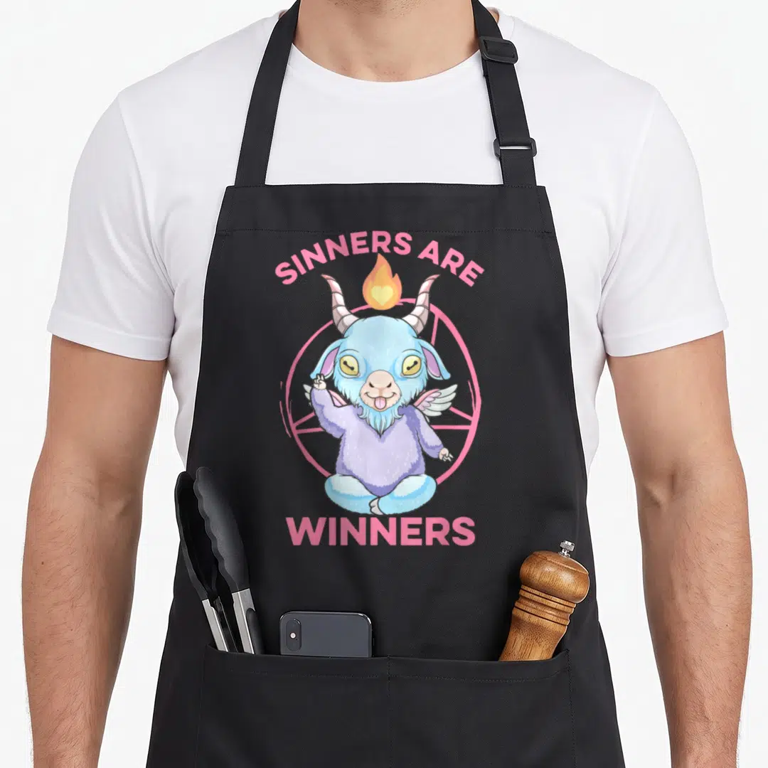 Baby anime cooking apron - Cartoon blue demon goat with pink text sinners are winners and heart flame — shown on a black cotton canvas apron against a white background