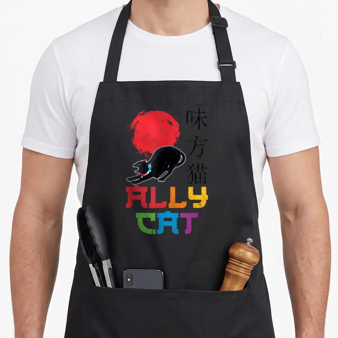 Ally cat apron - Black cat leaping before red sun with rainbow ALLY CAT text and vertical kanji — shown on a black cotton canvas apron against a white background