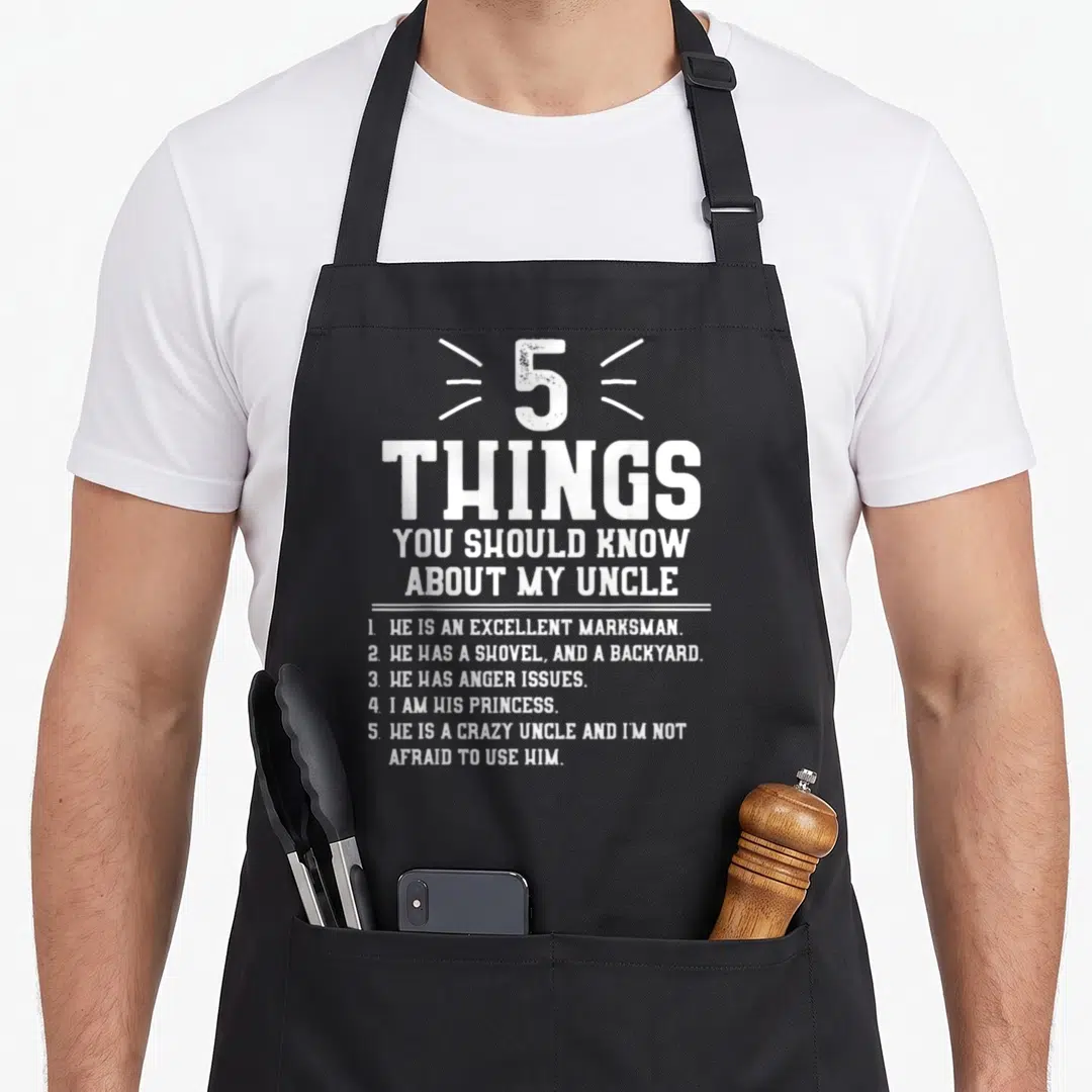 Should niece apron - White distressed text listing 5 things to know about a crazy uncle with a shovel and anger issues — shown on a black cotton canvas apron against a white background