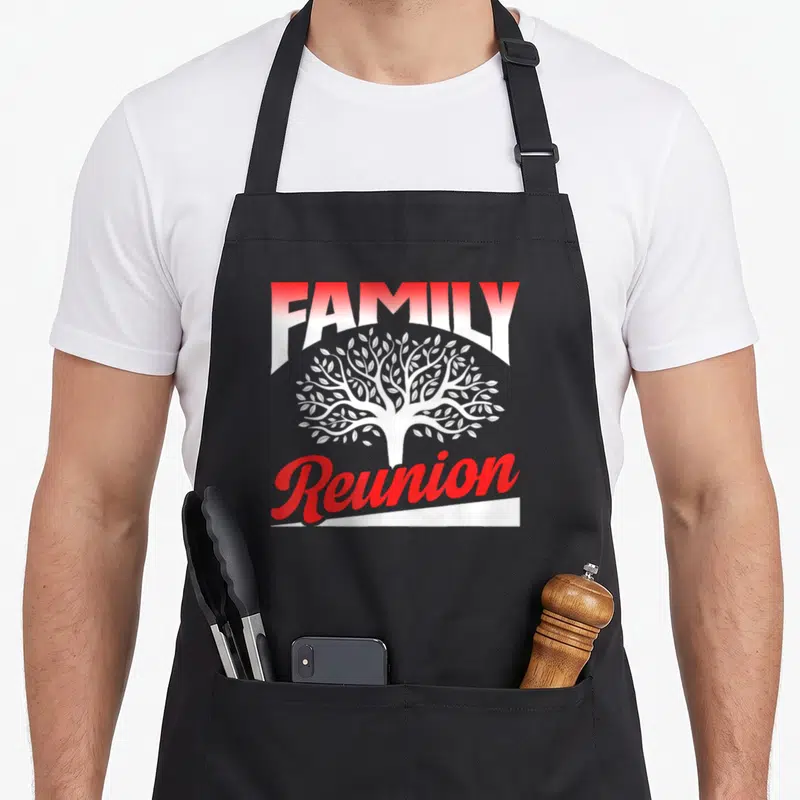 Funny reunion gathering apron - Red and white FAMILY Reunion text with white tree silhouette — shown on a black cotton canvas apron against a white background