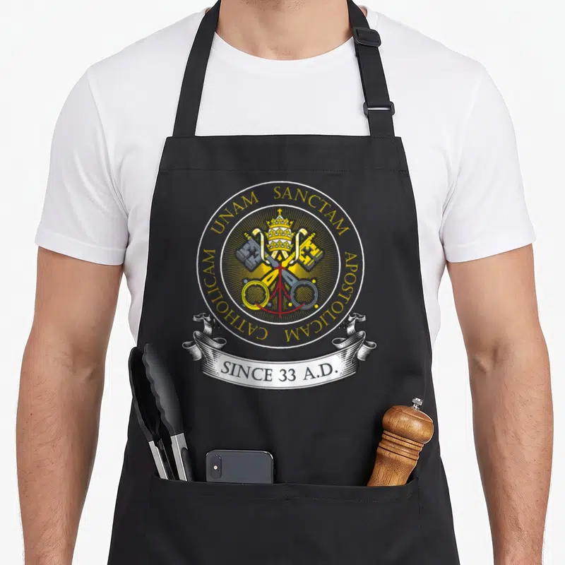 Holy catholic apron - Papal tiara crossed keys gold ring unam sanctam since 33 ad ribbon — shown on a black cotton canvas apron against a white background