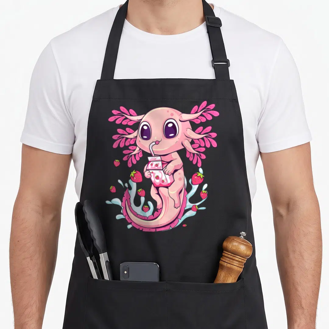 Strawberry anime cooking apron - Pink axolotl holding strawberry milk carton surrounded by floating red berries — shown on a black cotton canvas apron against a white background