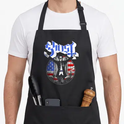 Emeritus papa apron - GHOST text above distressed circle with figure standing before flag and inverted crosses — shown on a black cotton canvas apron against a white background